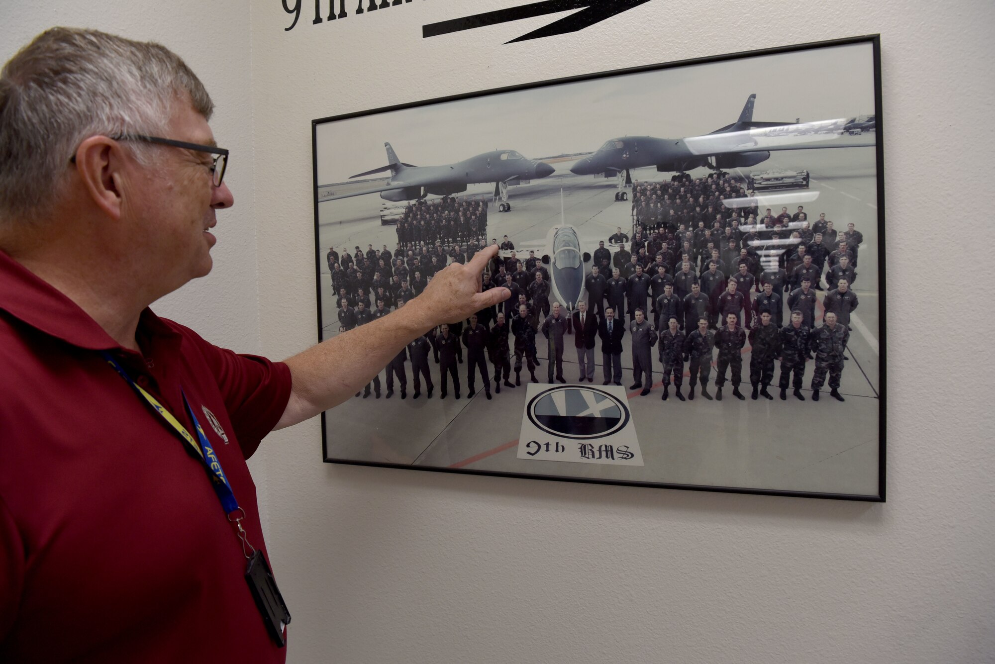 Philip Hermes, 7th Maintenance Group Air Force Engineering Technical Services program weapons system specialist, points to his unit’s group photo on Dyess Air Force Base, Texas, June 2, 2023. Hermes has served with the B-1B Lancers at Dyess since his arrival here in 1985. (U.S. Air Force photo by Senior Airman Sophia Robello)