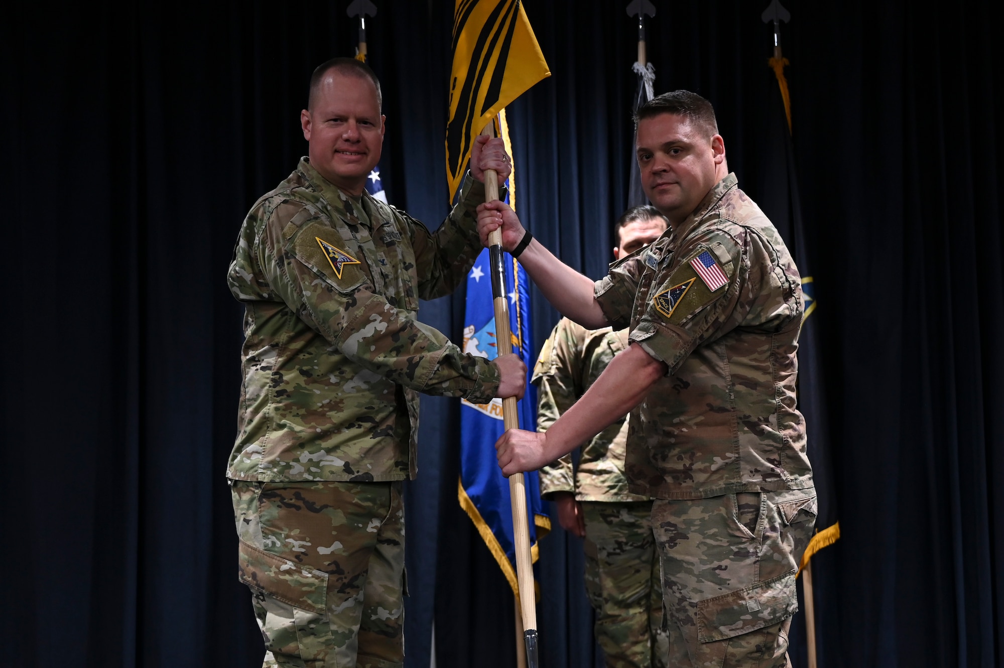 Two men stand on stage.