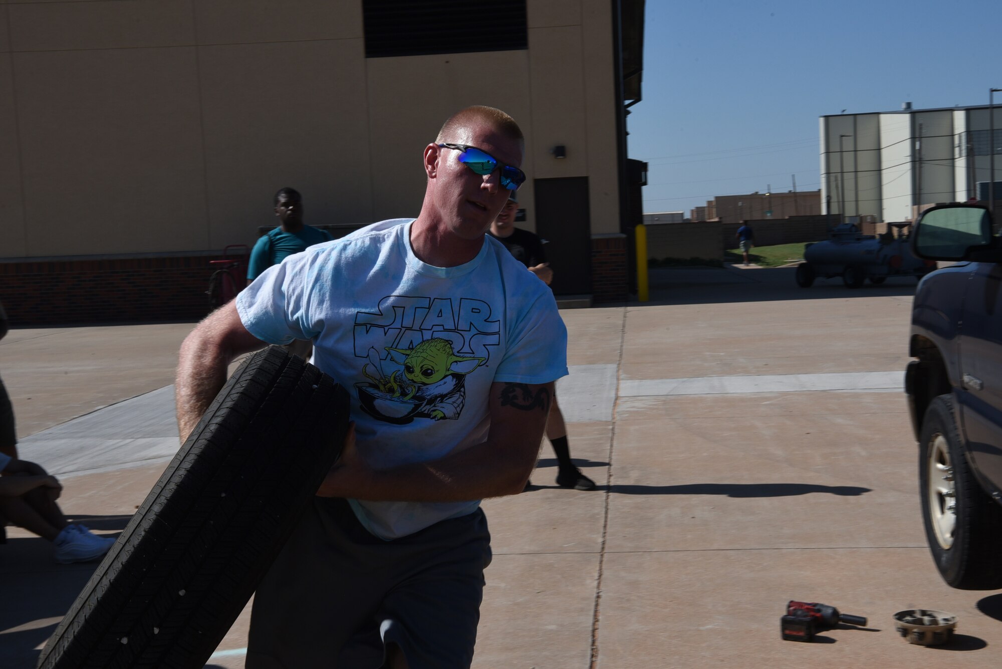 Airman 1st Class Shaun Tenney, 7th Logistics Readiness Squadron fuels distribution operator, carries a tire during the LRS Rodeo at Dyess Air Force Base, Texas, June 28, 2023. This is the first rodeo event for the 7th LRS at Dyess, held in celebration of National Logistics Day. (U.S. Air Force photo by Senior Airman Sophia Robello)