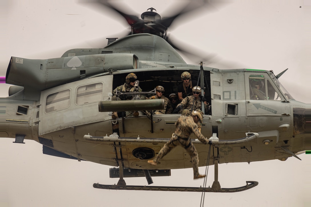 U.S. Marines with 1st Reconnaissance Battalion, 1st Marine Division, 4th Reconnaissance Battalion, 4th Marine Division, and 1st Air Naval Gunfire Liaison Company, I Marine Expeditionary Force Information Group, rappel out of a UH-1Y Venom during a helicopter rope suspension techniques course hosted by Expeditionary Operations Training Group, I MEF, at Marine Corps Base Camp Pendleton, California, June 13, 2023. The helicopter rope suspension techniques course creates HRST masters which are capable of supporting fast rope, rappel, and special patrol insertion/extraction operations from any U.S. Marine Corps helicopter and tiltrotor aircraft as a means to insert and extract ground forces into or from rough terrain and urban areas. (U.S. Marine Corps photo by Cpl. Gurule)