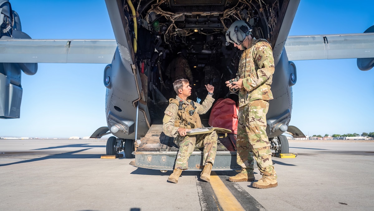 Maj. Kyle Konkolics, 71st Special Operations Squadron safety chief, goes over a pre-flight checklist with an air crew member May 10, 2023, at Kirtland Air Force Base, N.M. Konkolics received the Distinguished Flying Cross for his heroic role in a rescue mission of an American hostage in Africa in October 2020. The successful operation was the longest-distance hostage rescue conducted during night in Department of Defense history and was completed within 48 hours of their initial notification. (U.S. Air Force photo by Allen Winston)