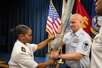 USMEPCOM headquarters battalion senior enlisted advisor Air Force Senior Master Sgt. Marc Ascher passes the unit guidon to Army Command Sgt. Maj. Yveline Symonette during a change of responsibility ceremony July 7. Symonette accepted responsibility as the new senior enlisted advisor of USMEPCOM HQ, succeeding Army Command Sgt. Maj. Lorenzo Woodson.