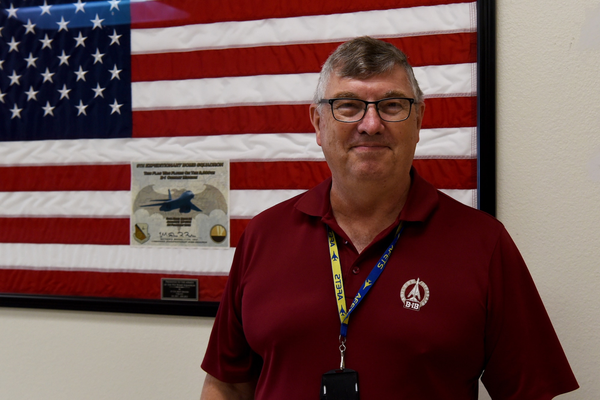 Philip Hermes, 7th Maintenance Group Air Force Engineering Technical Services program weapons system specialist, poses in front of the flag on Dyess Air Force Base, Texas, June 2, 2023. Hermes has served with the B-1B Lancers at Dyess since his arrival here in 1985. (U.S. Air Force photo by Senior Airman Sophia Robello)