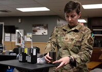 An Air Force captain looks at devices placed on a table.