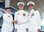 Rear Adm. Douglas M. Schofield, commander of the Seventh Coast Guard District, Cmdr. Sarah Brennan, the Marine Safety Unit Port Canaveral Commander, and Lt. Cmdr. John Di Nino, the former MSU Port Canaveral Commander, pose for a photo during a Change of Command ceremony at Port Canaveral, Florida, July 7, 2023. During the ceremony, Brennan relieved Di Nino as the MSU Port Canaveral Commander. (U.S. Coast Guard photo by Coast Guard Auxiliary member Jill Bazeley)