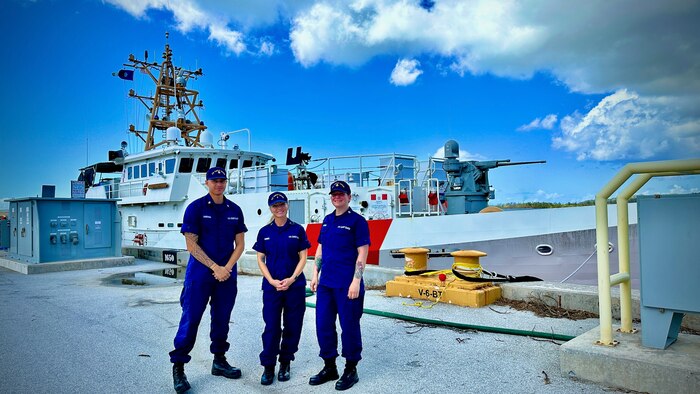 Petty Officer 1st Class Gabriella Carson, Chief Warrant Officer Jessica Cramer, and Petty Officer 2nd Class Manuel Sardinha, part of the deployed Family Assessment Support Tool (FAST) team in Guam stand for a photo by the USCGC Frederick Hatch (WPC 1143) on June 13, 2023. The U.S. Coast Guard's Family Assessment Support Tool (FAST) implementation has revolutionized disaster response and support efforts. By proactively identifying and addressing personnel needs, FAST ensures the stabilization and well-being of Coast Guard members and their families during crises. (U.S. Coast Guard photo by Chief Warrant Officer Sara Muir)