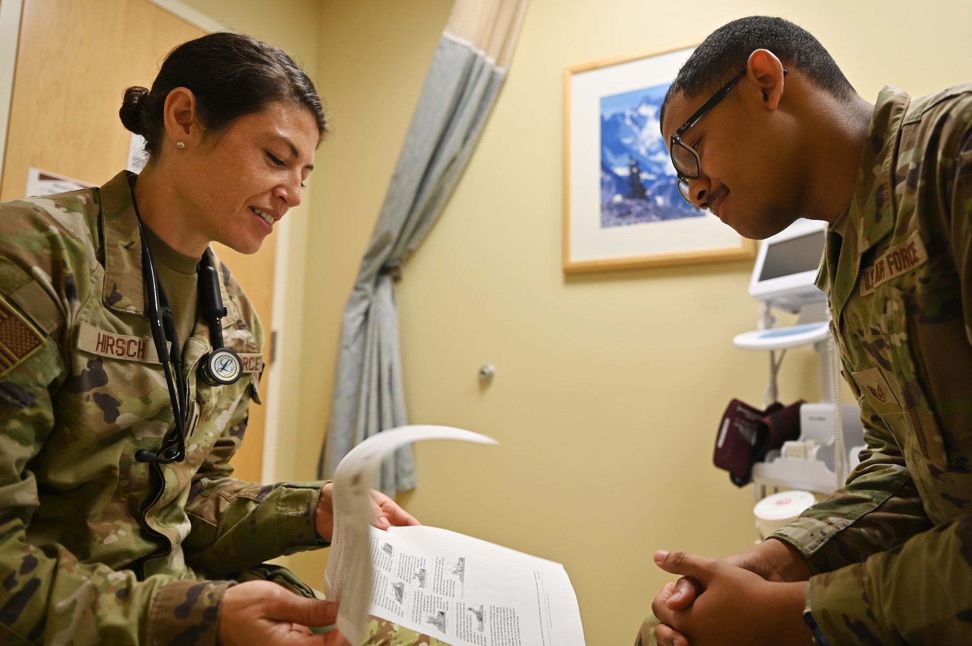 U.S. Air Force 1st Lt. Sarah Hirsch, left, a physician assistant with the 62d Medical Squadron, reviews a pamphlet with a patient at the Warrior Operational Medicine Clinic at Joint Base Lewis-McChord, Washington, July 6, 2023. Hirsch received recognition from her peers for her continuous positive outlook, ability to foster unit cohesiveness and for developing a crossfit training program for the 62d Aerial Port Squadron. (U.S. Air Force photo by Senior Airman Colleen Anthony)