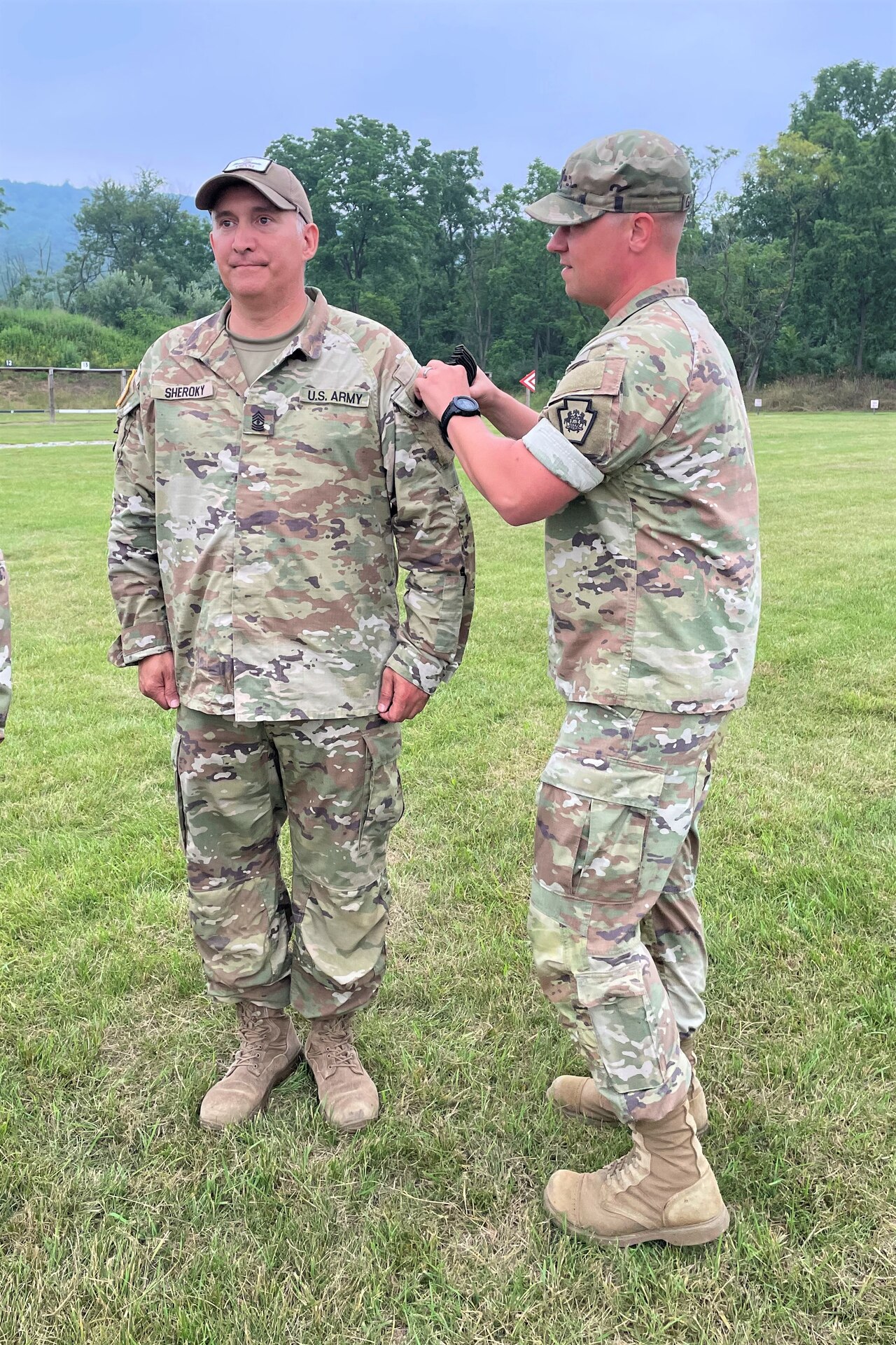 Overall first-place finisher 1st Sgt. Scott Sheroky, left, of the Eastern Army National Guard Aviation Training Site, receives his Governor's Twenty uniform tab from Capt. Shawn Garghill, chief of the Pennsylvania Army National Guard Individual Training Branch, at the conclusion of the annual Governor’s Twenty marksmanship competition July 1, 2023, at Fort Indiantown Gap, Pa. (Courtesy photo)