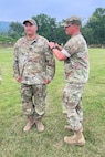 Overall first-place finisher 1st Sgt. Scott Sheroky, left, of the Eastern Army National Guard Aviation Training Site, receives his Governor's Twenty uniform tab from Capt. Shawn Garghill, chief of the Pennsylvania Army National Guard Individual Training Branch, at the conclusion of the annual Governor’s Twenty marksmanship competition July 1, 2023, at Fort Indiantown Gap, Pa. (Courtesy photo)
