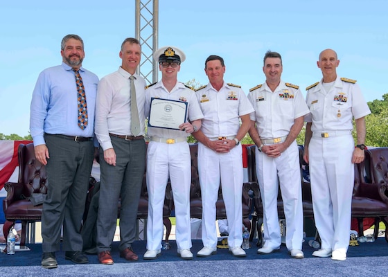 Adm. James F. Caldwell Jr., director, Naval Nuclear Propulsion Program, right, Royal Australian Navy Vice Adm. Jonathan Mead, director-general of the Australian Submarine Agency, Royal Australian Navy Lt. William Hall, Royal Australian Navy Vice Adm. Mark Hammond, Chief of Navy, the Honorable Erik Raven, Under Secretary of the Navy, and Abraham M. Denmark, Senior Advisor to the Secretary of Defense for AUKUS, pose for a photo during a United States Naval Nuclear Power School (NPS) graduation ceremony at Naval Nuclear Power Training Command (NNPTC), July 7, 2023. Three Royal Australian Navy (RAN) officers graduated NPS, marking a significant step in Australia's goal to operate conventionally-armed, nuclear-powered attack submarines (SSNs). (U.S. Navy photo by Mass Communication Specialist 2nd Class Dart D. De La Garza)