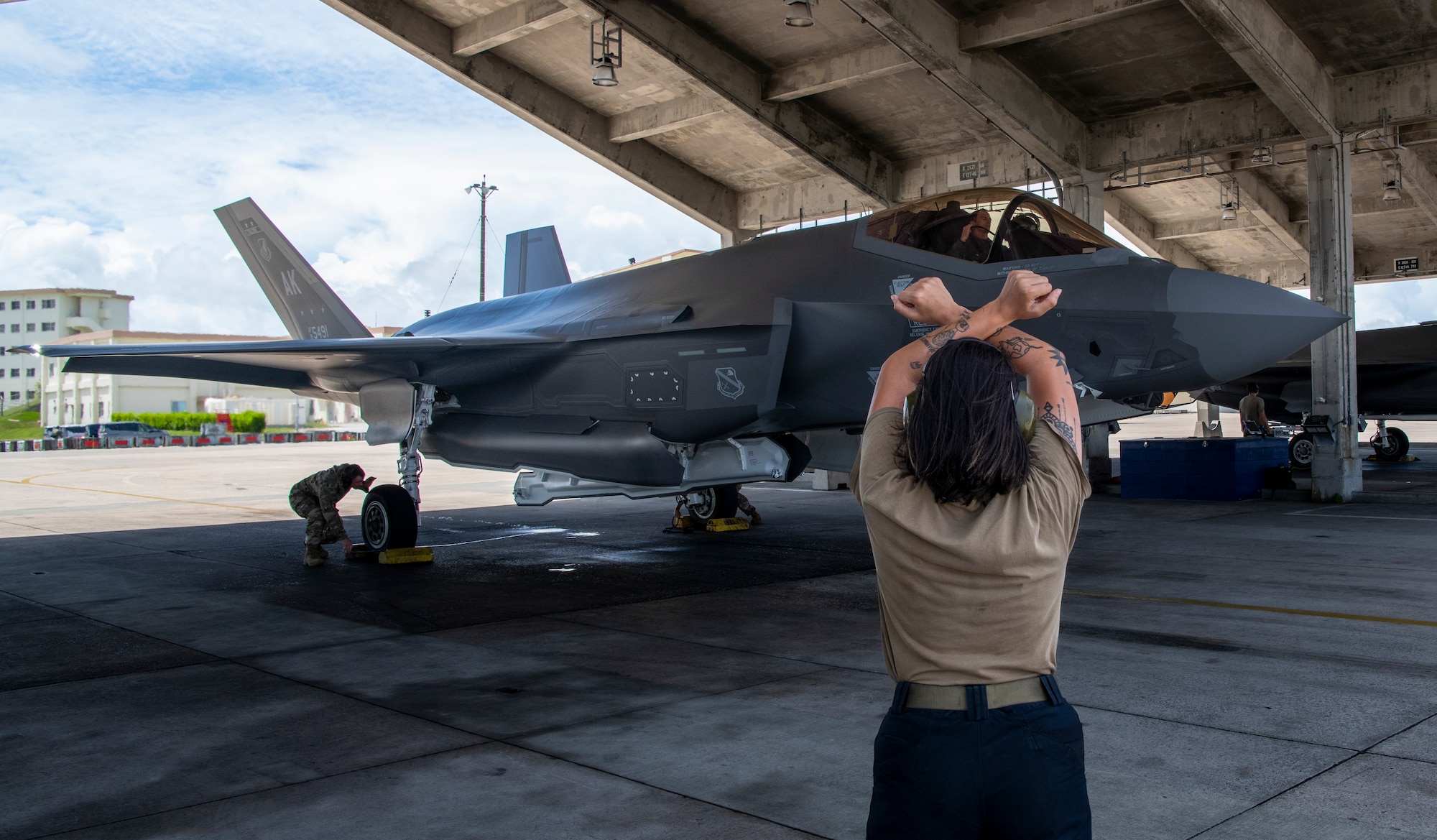 U.S. Air Force Staff Sgt. Keyli Pillaro-Estrada, 355th Fighter Generation Squadron, crew chief, Eielson Air Force Base, Alaska, signals an F-35 pilot during Northern Edge 23-2 at Kadena Air Base, Japan, July 4, 2023.