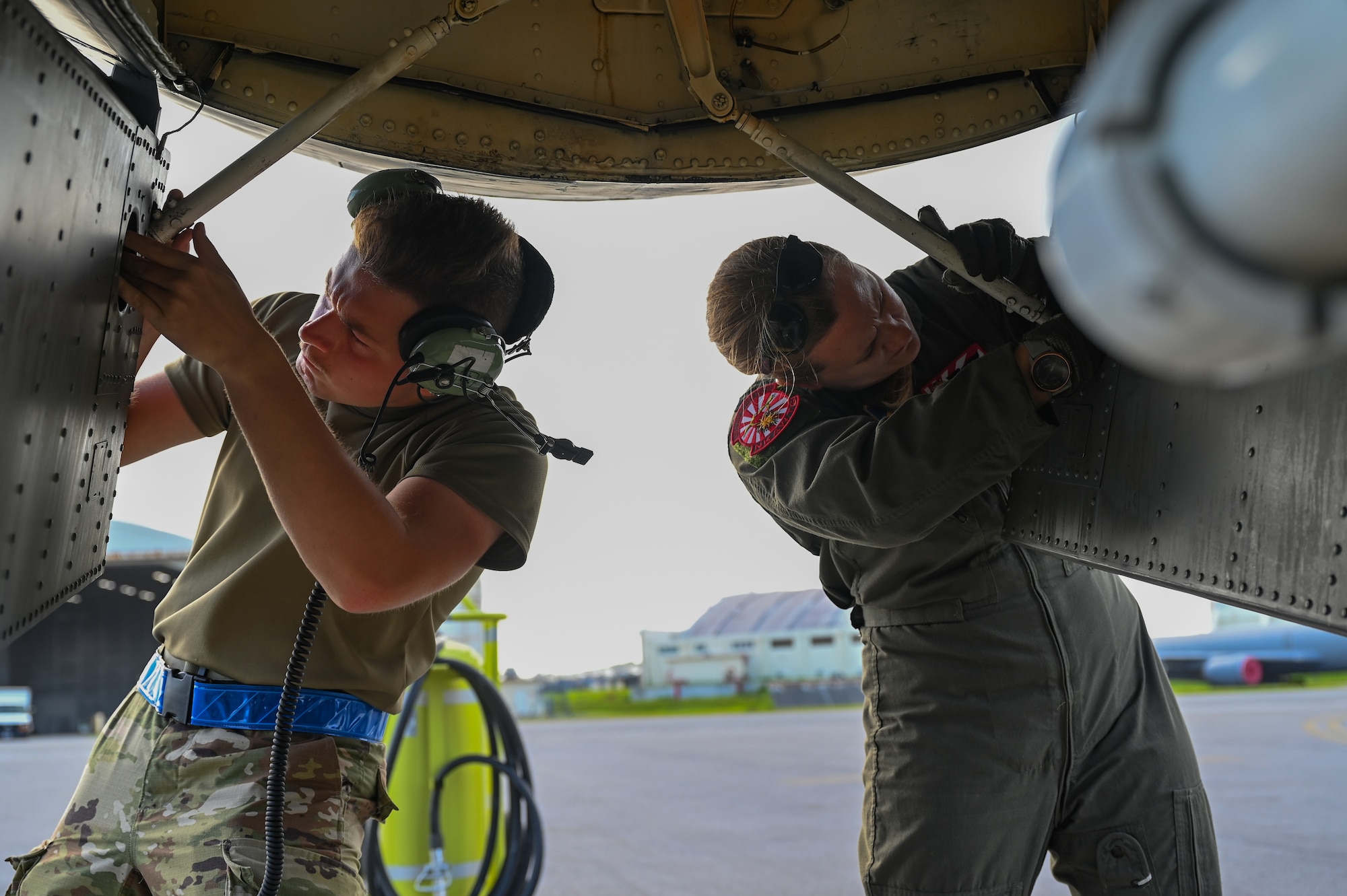 Airmen connect hydraulic latches to a landing gear door.