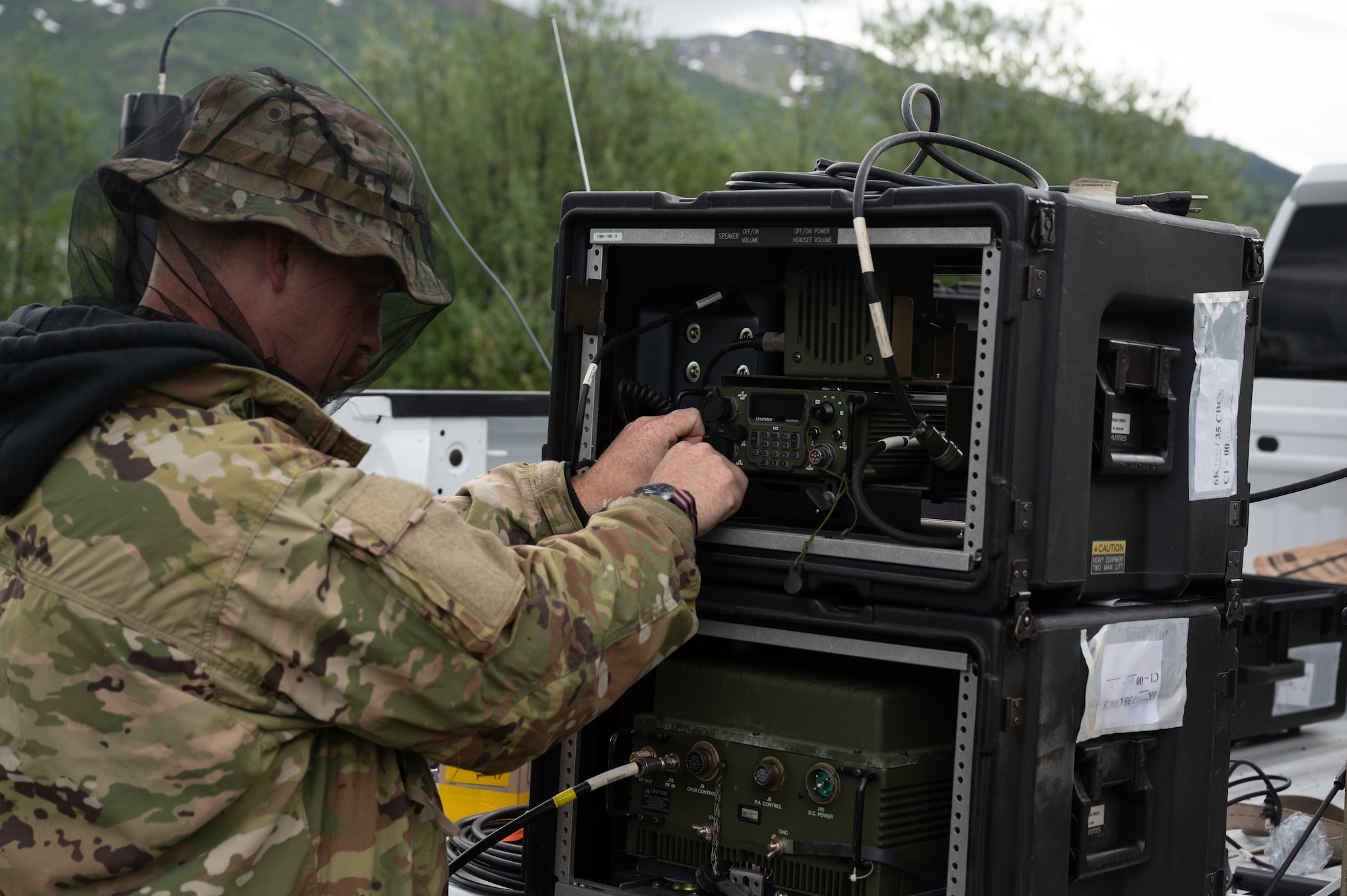 U.S. Air Force Tech Sgt. Laramie Grisba, a radio frequency transmission systems specialist, 55th Combat Communications Squadron, Tinker Air Force Base, Oklahoma attaches a high frequency radio communication device to a protective frame while getting communications set up in Coldfoot, Alaska as part of Exercise AGILE BLIZZARD-UNIFIED VISION Phase II on June 11, 2023. The equipment for the Alaska portion of the exercise was powered, almost exclusively, by electrical power derived from the convoy vehicles and batteries. (U.S. Air Force photo by Staff Sgt. Dana Tourtellotte)