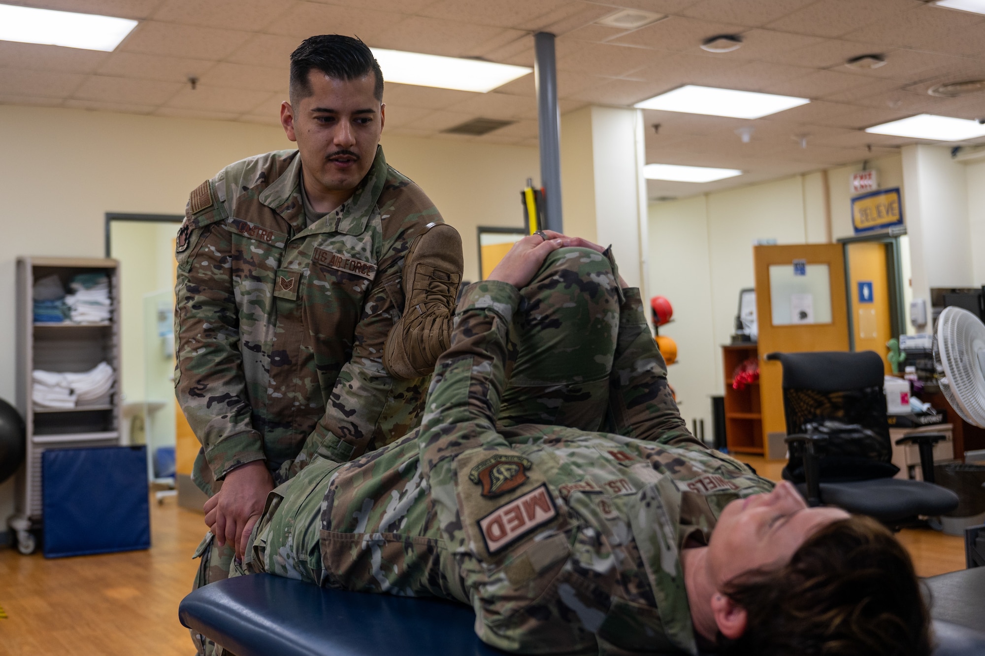 SSgt Alejandro Castro stretches out Capt. Fern Daniels during a therapy session at Kunsan Air Base, Republic of Korea, July 7, 2023.