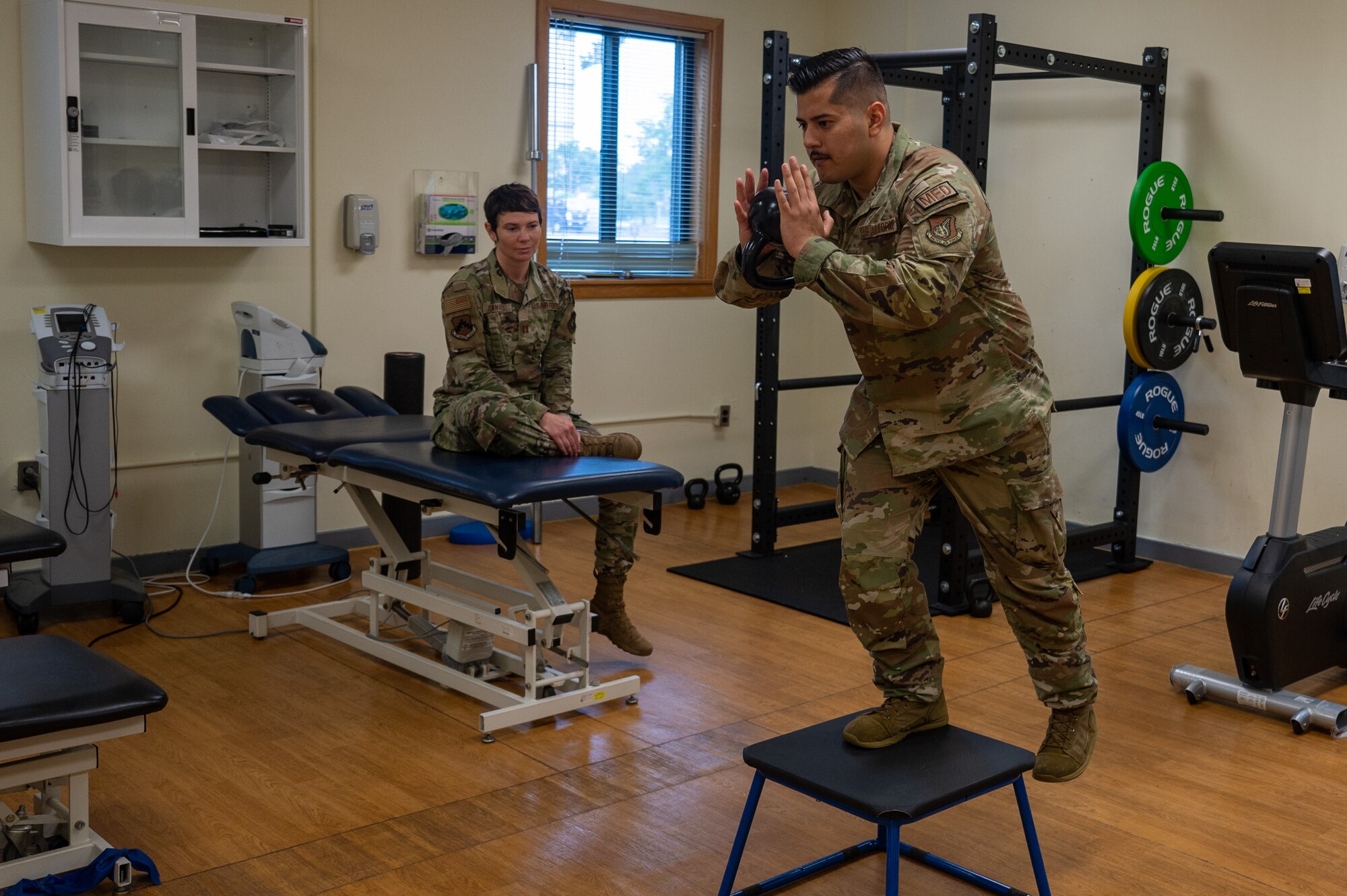 SSgt Alejandro Castro demonstrates how a patient should perform an exercise during a therapy session.