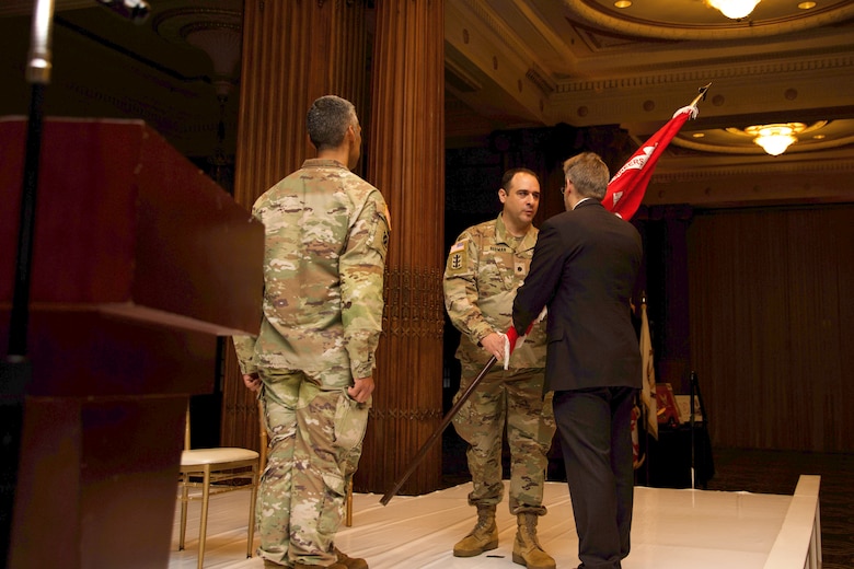 Photo shows exchange of USACE flag/unit colors during a ceremony