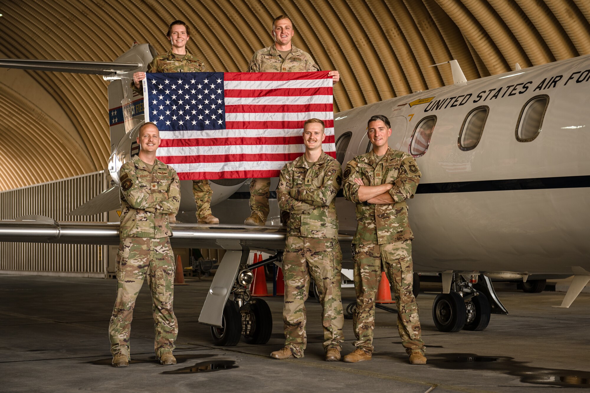 Photo of Airmen holding an American flag