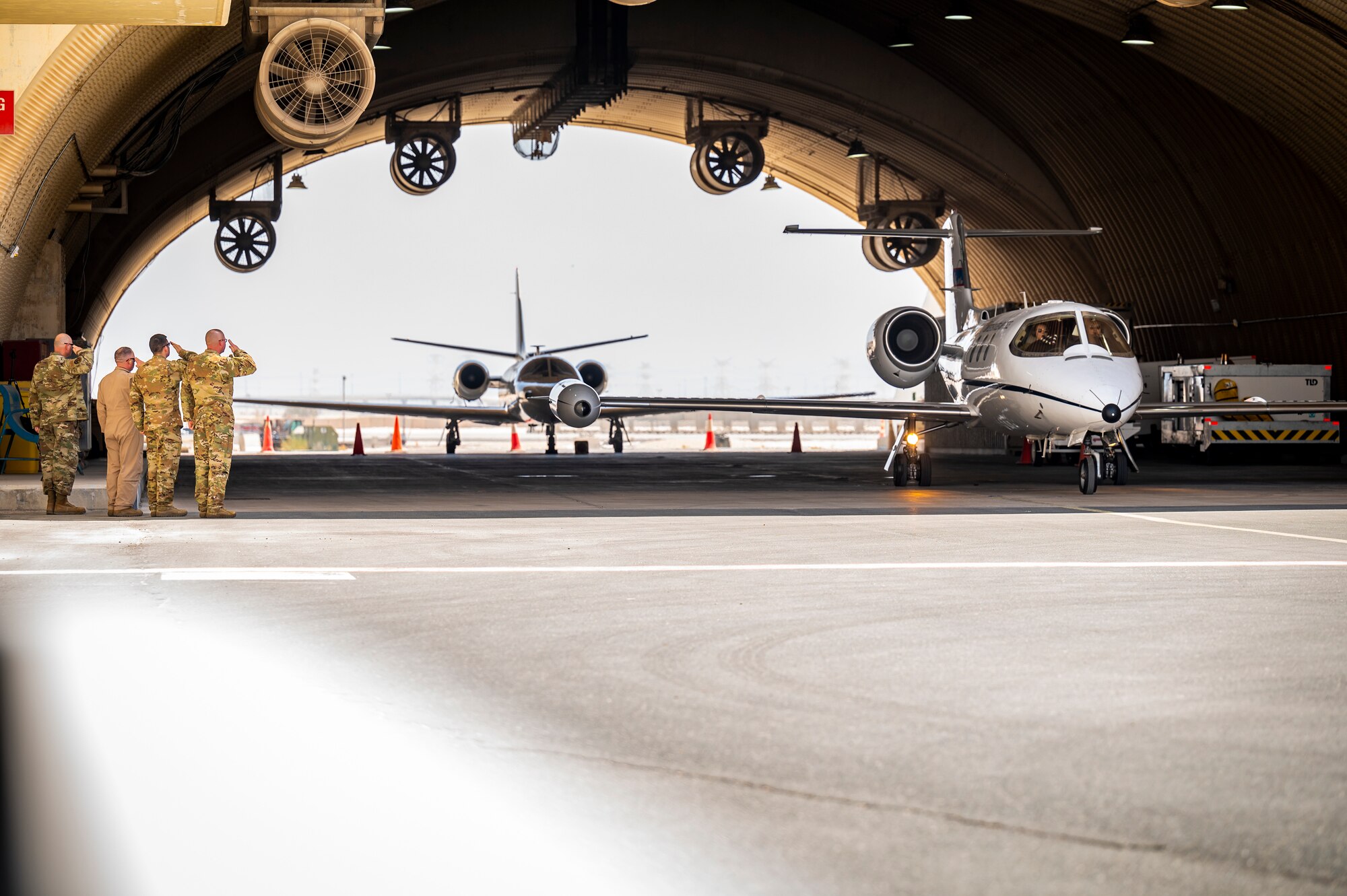 Photo of Airmen saluting an aircraft