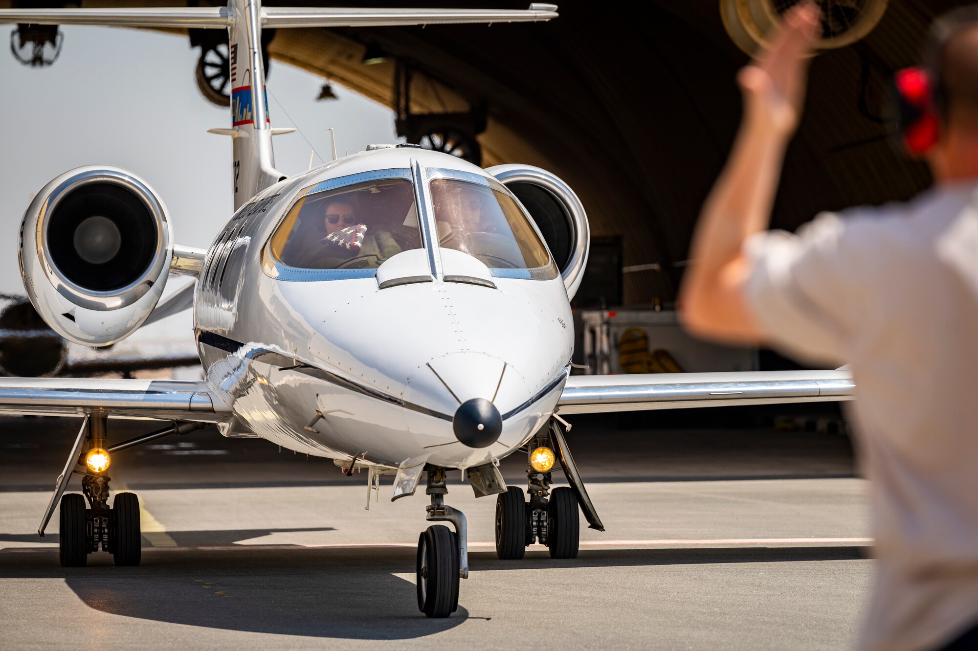 Photo of Airman marshaling an aircraft