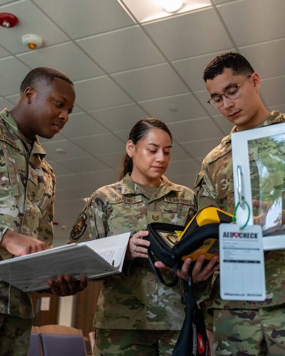 Staff Sgt. Khalil Armstrong and Senior Airman Adam Obregon train Tech. Sgt. Shelly Martinez, 482d Medical Squadron, on inspecting the Automated External Defibrillator (AED) during their monthly inspection on July 8, 2023, at Homestead Air Reserve Base, Florida. The AED is a user-friendly medical device that can analyze the heart's rhythm and, if required, provide an electrical shock or defibrillation to assist the heart in regaining a regular rhythm. (U.S. Air Force photo by Tech. Sgt. Paul Cook)