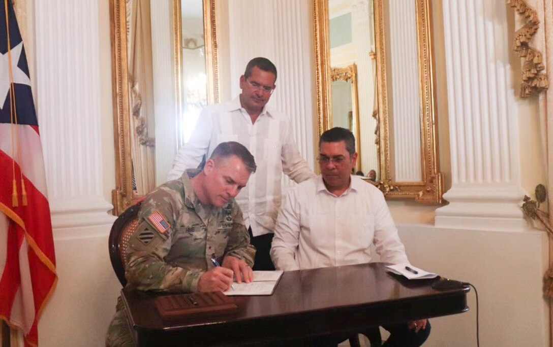 South Atlantic Division Commander, signs a memorandum of agreement for Guajataca Dam Permanent Repairs, the govenor of Puerto Rico and the Exec. Engineer of PREPA watch