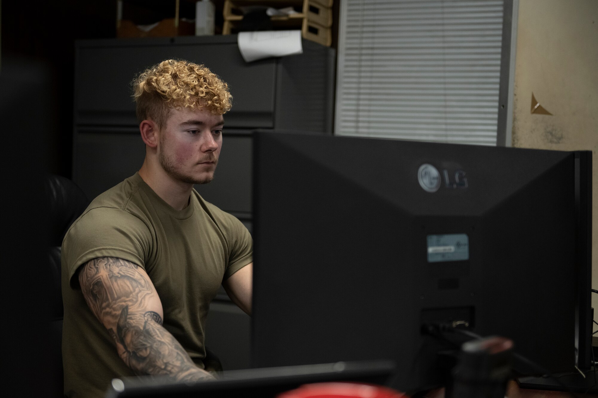 A photo of a person sitting at a computer.