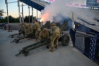 Members of 145th Field Artillery provide a cannon salute to start Stadium of Fire celebrations