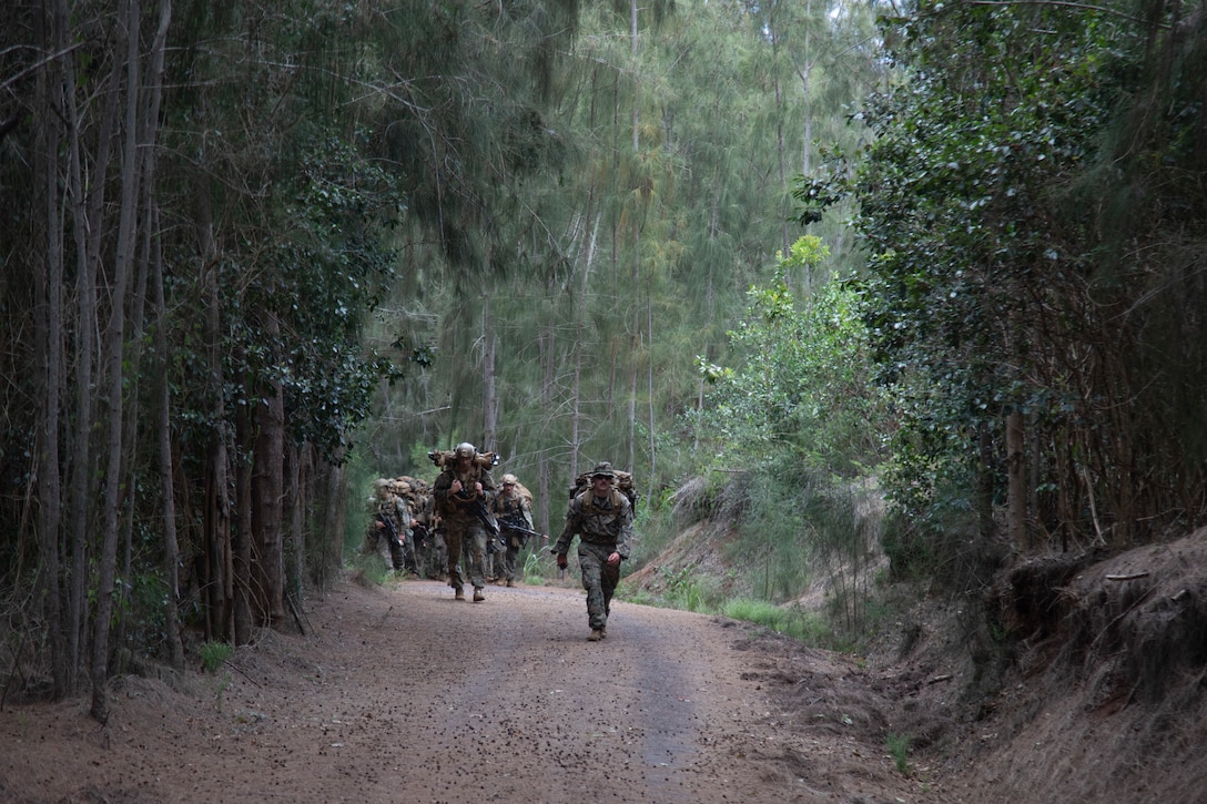 U.S. Marines with Advanced Infantry Training Battalion, School of Infantry-West, Hawaii Detachment, head to an equipment staging area during an Advanced Infantry Marine Course, Kahuku Training Area, Hawaii, June 26, 2023. AIMC is advanced infantry training designed to enhance and test Marines’ skills with a focus on reinforcing proper patrols and operational procedures. (U.S. Marine Corps photo by Lance Cpl. Terry Stennett III)