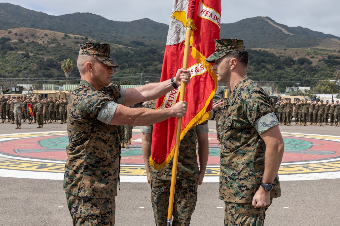 U.S. Marine Corps Lt. Col. Kurt Stahl, left, the incoming commanding officer for Headquarters and Support Battalion, School of Infantry West, receives the colors from Lt. Col. James Woulfe, the outgoing commanding officer, during a change of command ceremony at the SOI-West parade deck on Camp Pendleton, June 29, 2023. H&S Bn., SOI-West provides the operational, administrative, logistical, and legal services necessary to support the School of Infantry's training units.  (U.S. Marine Corps photo by Lance Cpl. Mhecaela J. Watts)