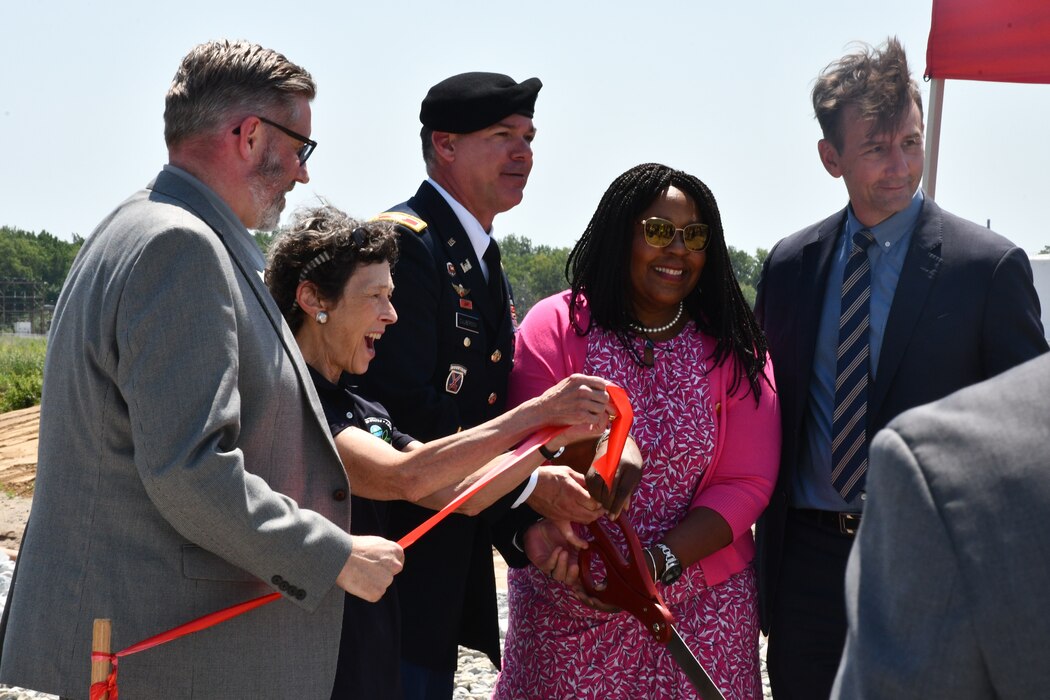 Group of government employees cut a ribbon at ceremony