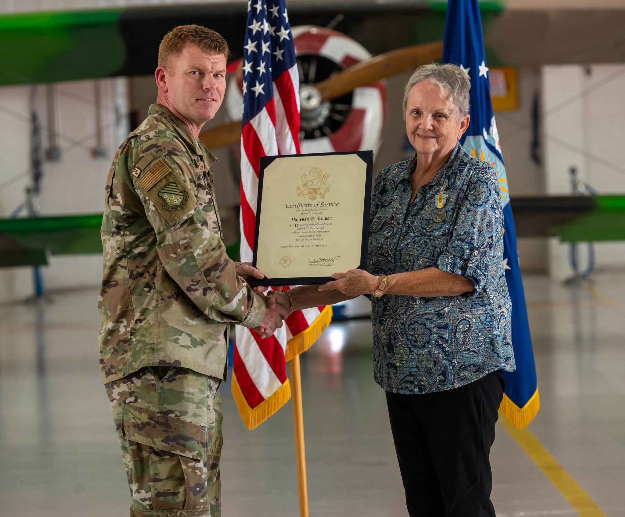 U.S. Air Force Col. Neal Van Houten, 1st Maintenance Group commander, presents a Certificate of Service to Vanessa Linden, 1st Maintenance Group commander’s executive assistant, during her retirement ceremony at Joint Base Langley-Eustis, Virginia, June 30, 2023.