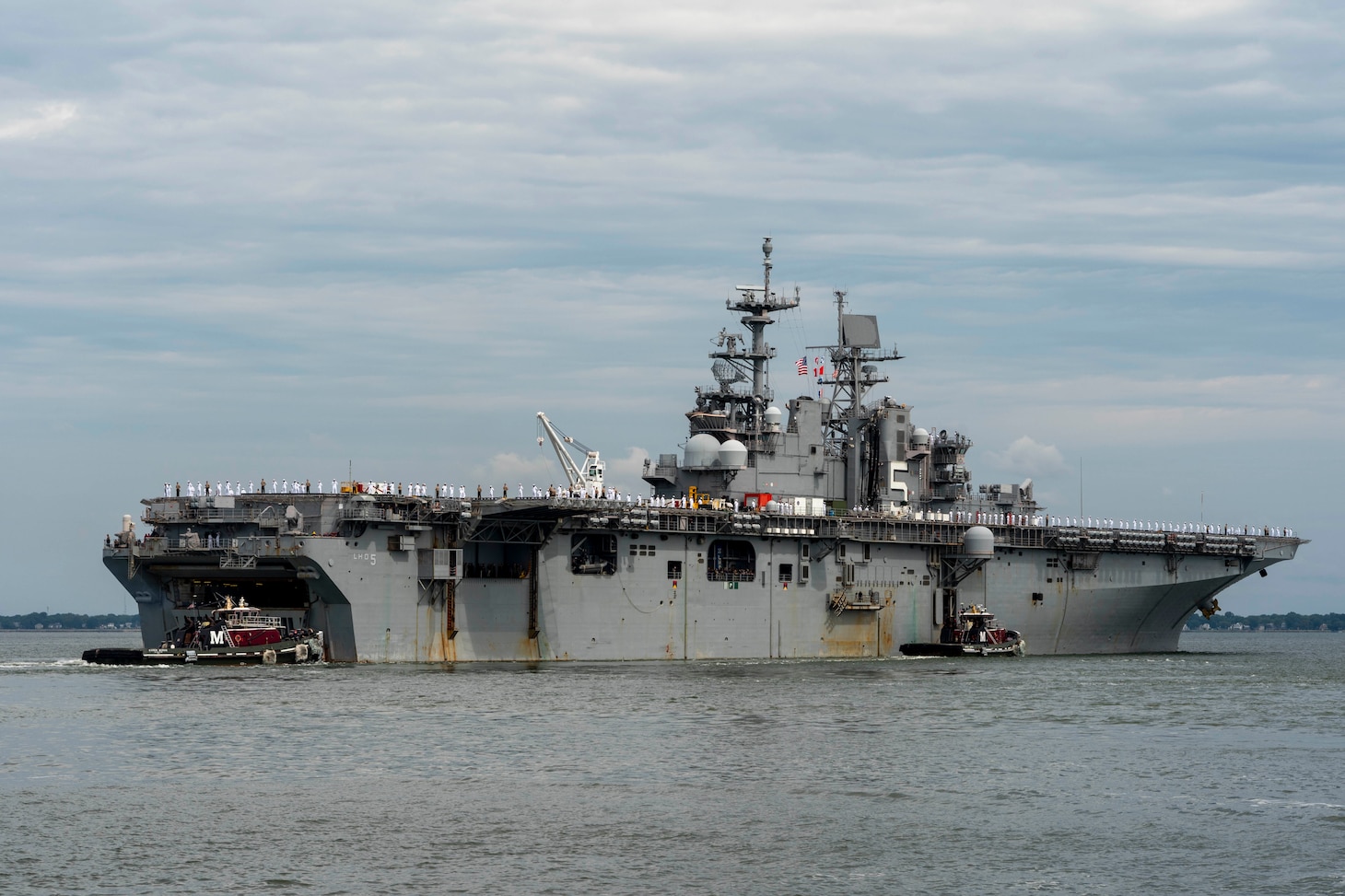 The amphibious assault ship USS Bataan (LHD 5) departs Naval Station Norfolk for a scheduled deployment, July 10, 2023.