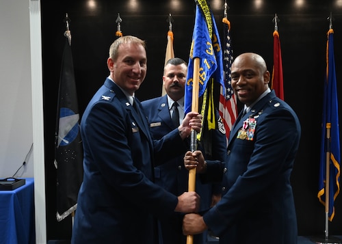 U.S. Air Force Lt. Col. Erwin Mason, outgoing 316th Training Squadron commander, passes the guidon to Col. Jason Kulchar, 17 Training Group commander, relinquishing command during the change of command ceremony at the Powell Event Center, Goodfellow Air Force Base, Texas, July 7, 2023. Passing the guidon represents the transfer of leadership responsibilities to the next commander. (U.S. Air Force photo by Airman 1st Class Madison Collier)