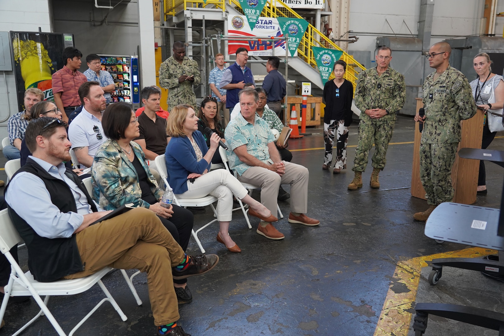 Deputy Secretary of Defense Kathleen Hicks, center, asks Officer in Charge of Construction, Pearl Harbor Naval Shipyard Capt. Stephen Padhi, right, a question during a briefing at Pearl Harbor Naval Shipyard.