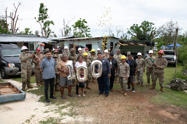 Guam residents and members of Task Force RISEUP, which is short for Roofing Installation Support Emergency Utilization Program, celebrate completion of the 100th temporary, emergency roof install during recovery efforts following Typhoon Mawar, June 27, 2023.  The U.S. Department of Defense and USACE, in coordination with the Federal Emergency Management Agency and the U.S. Territory of Guam, launched RISEUP to help temporarily repair metal roofs damaged by Typhoon Mawar which made land fall May 25.