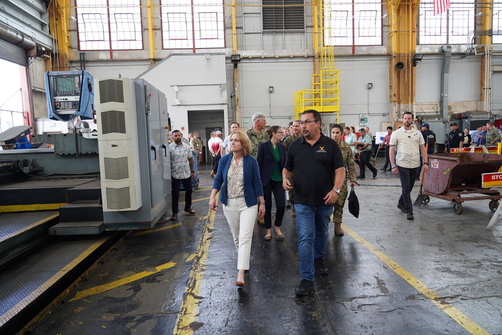 Deputy Secretary of Defense Kathleen Hicks, left, receives a briefing from John Morgan, right, Mechanical Superintendent for Code 930 (Shops 931/938) during a tour of Pearl Harbor Naval Shipyard.