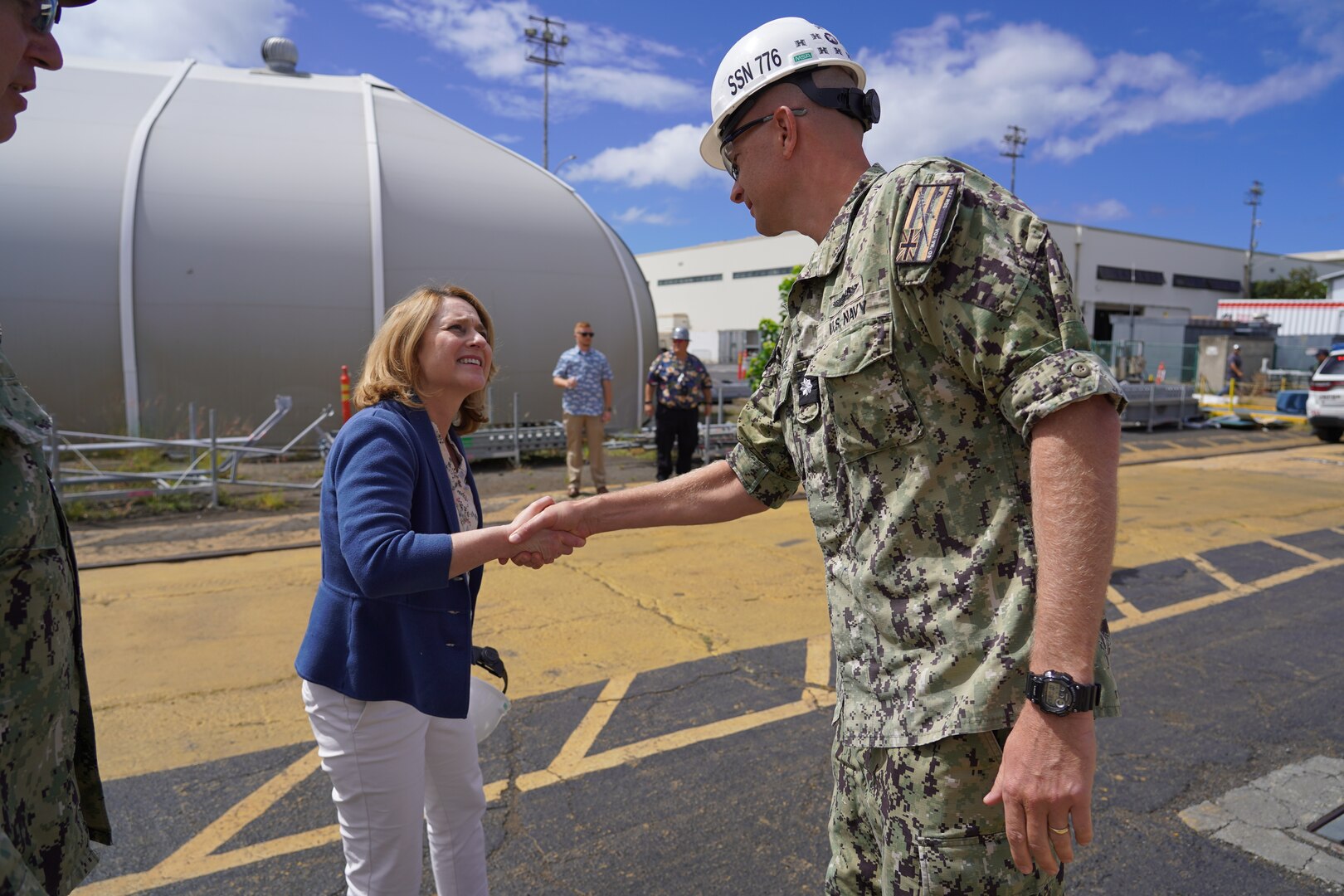 Deputy Secretary of Defense Kathleen Hicks, left, meets Commanding Officer of USS Hawaii, Cdr. Preston Gilmore, right, at Dry Dock 1 during a tour of Pearl Harbor Naval Shipyard.