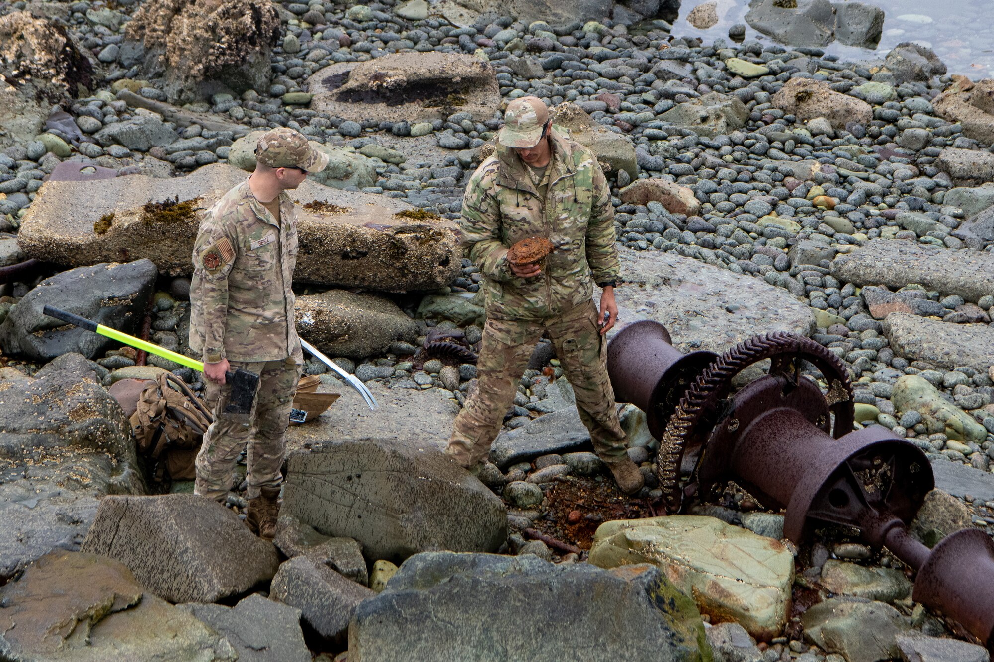 A photo of two EOD members inspecting a suspected UXO.