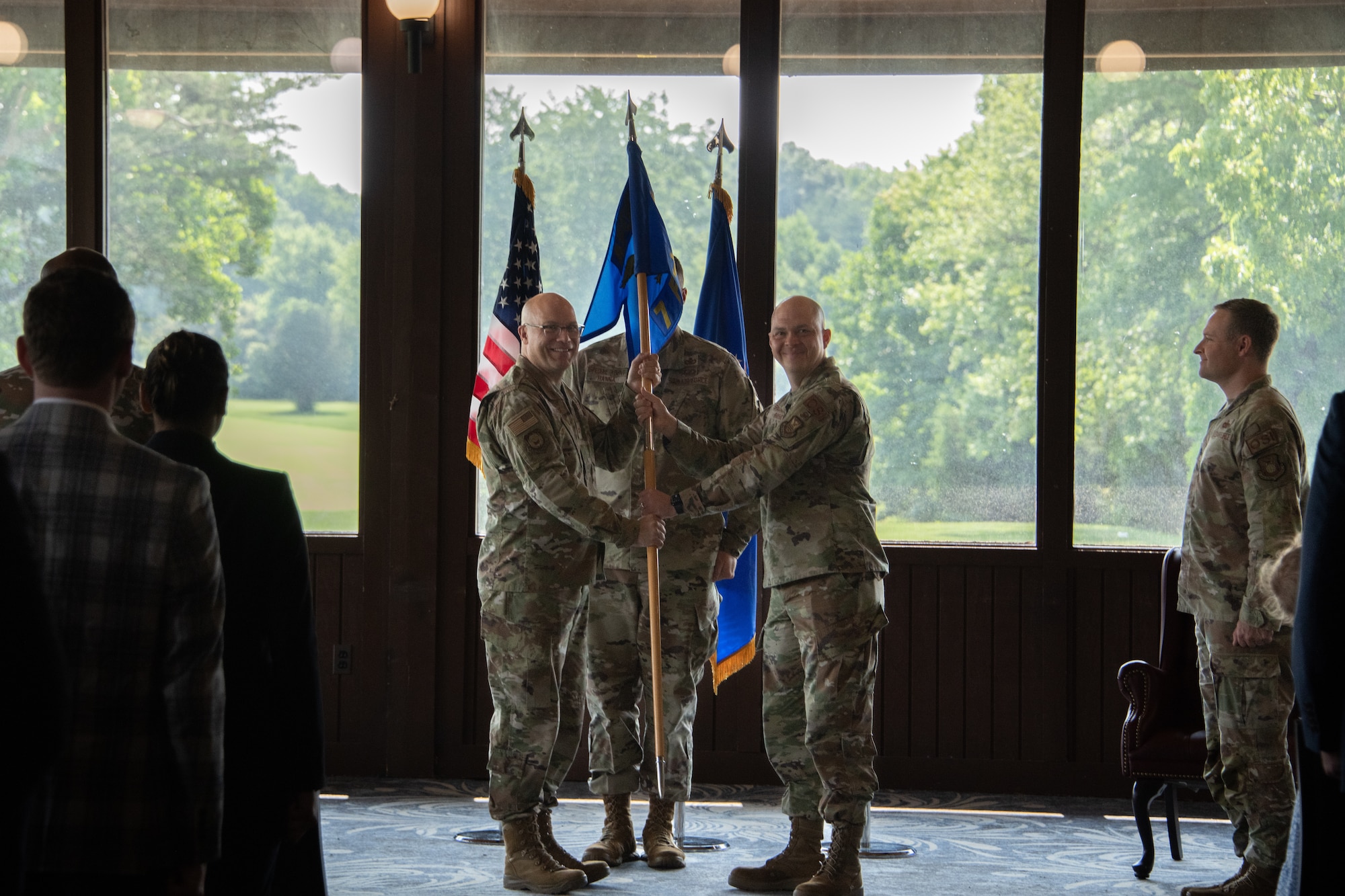 Col. Brian Alexander, Air Force Office of Special Investigations commander, hands the 7th Field Investigations Squadron guidon to Lt Col. John Rayho, 7th FIS new commander