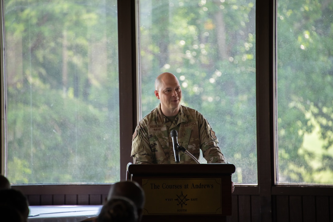 t Col. John Rayho the incoming 7th Field Investigations Squadron commander, speaks at a podium during the 7th FIS change of command ceremony