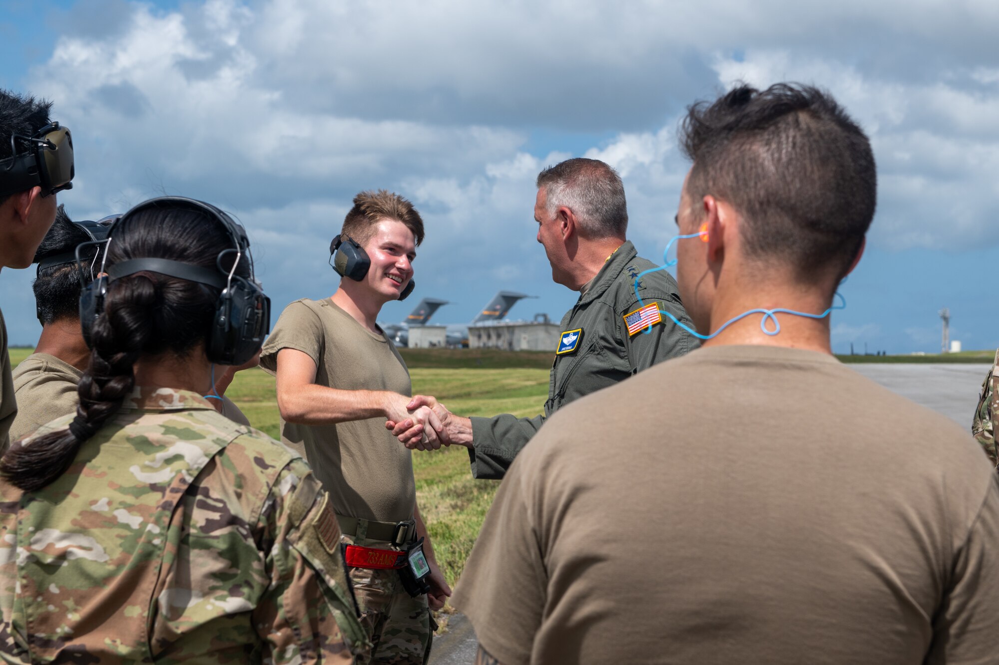Four star general shakes Airman's hand.
