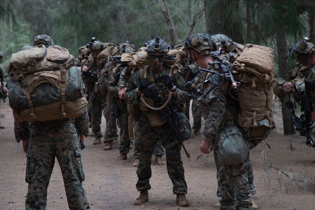 U.S. Marines with Advanced Infantry Training Battalion, School of Infantry-West, Hawaii Detachment, head to an equipment staging area during an Advanced Infantry Marine Course, Kahuku Training Area, Hawaii, June 26, 2023. AIMC is advanced infantry training designed to enhance and test Marines’ skills with a focus on reinforcing proper patrols and operational procedures. (U.S. Marine Corps photo by Lance Cpl. Terry Stennett III)
