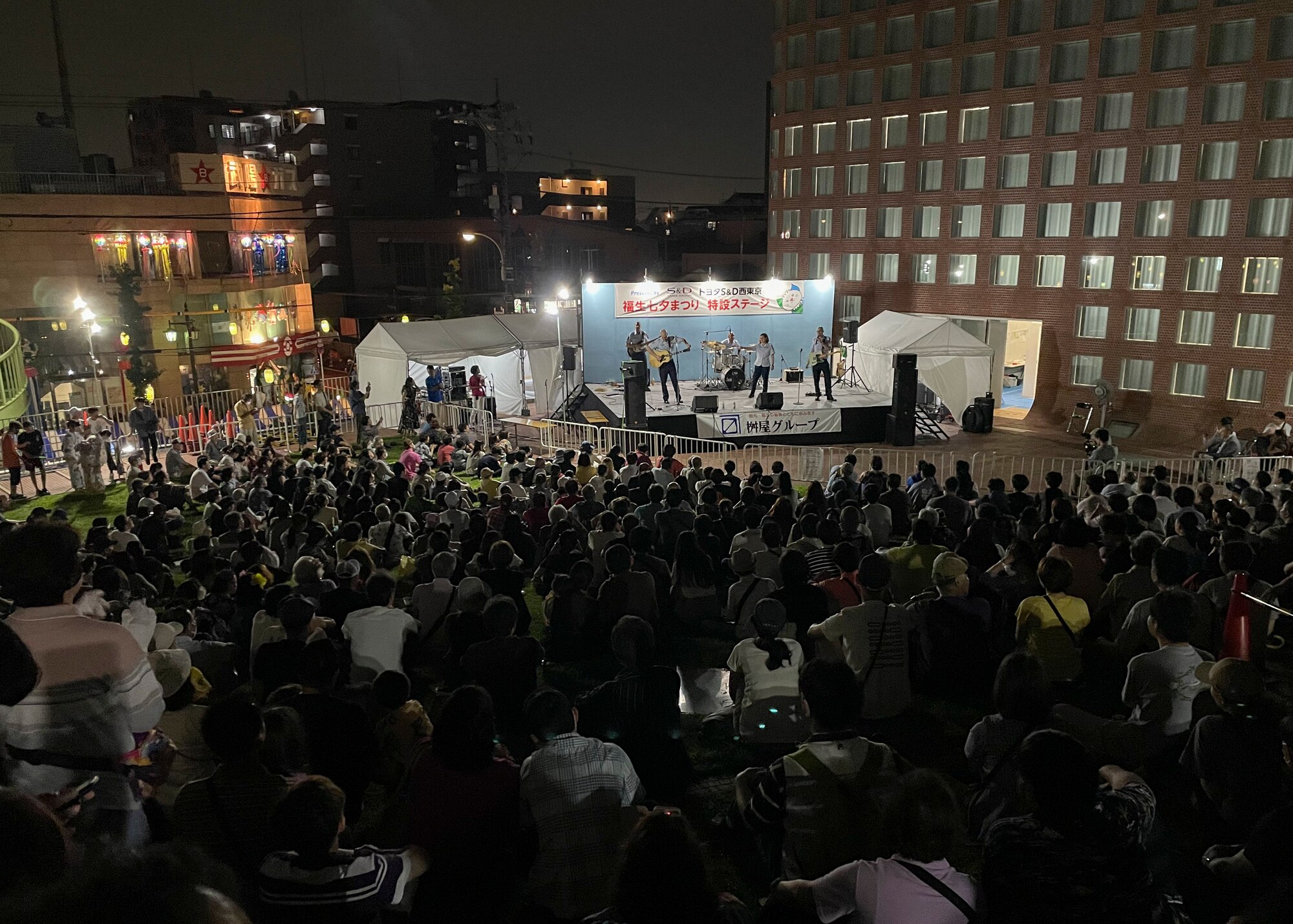 A large crowd watches a military band