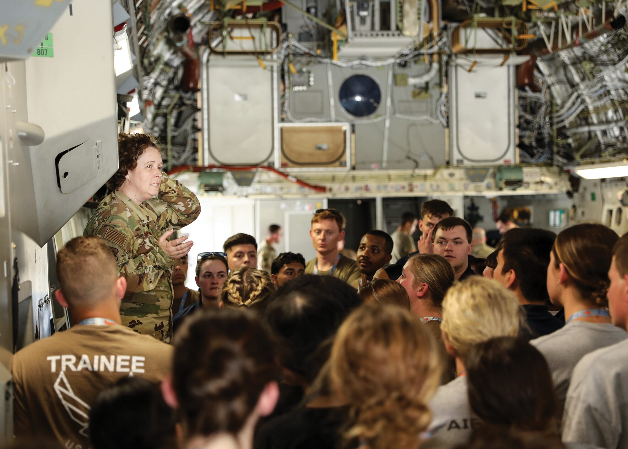 Master Sgt. Caroline Sussman, 89th Airlift Squadron loadmaster, explains the C-17 Globemaster III mission to 70 Development and Training Flight members from the 445th Airlift Wing; Grissom Air Reserve Base, Indiana; and Youngstown Air Reserve Station, Ohio, during an aircraft tour, June 3, 2023.