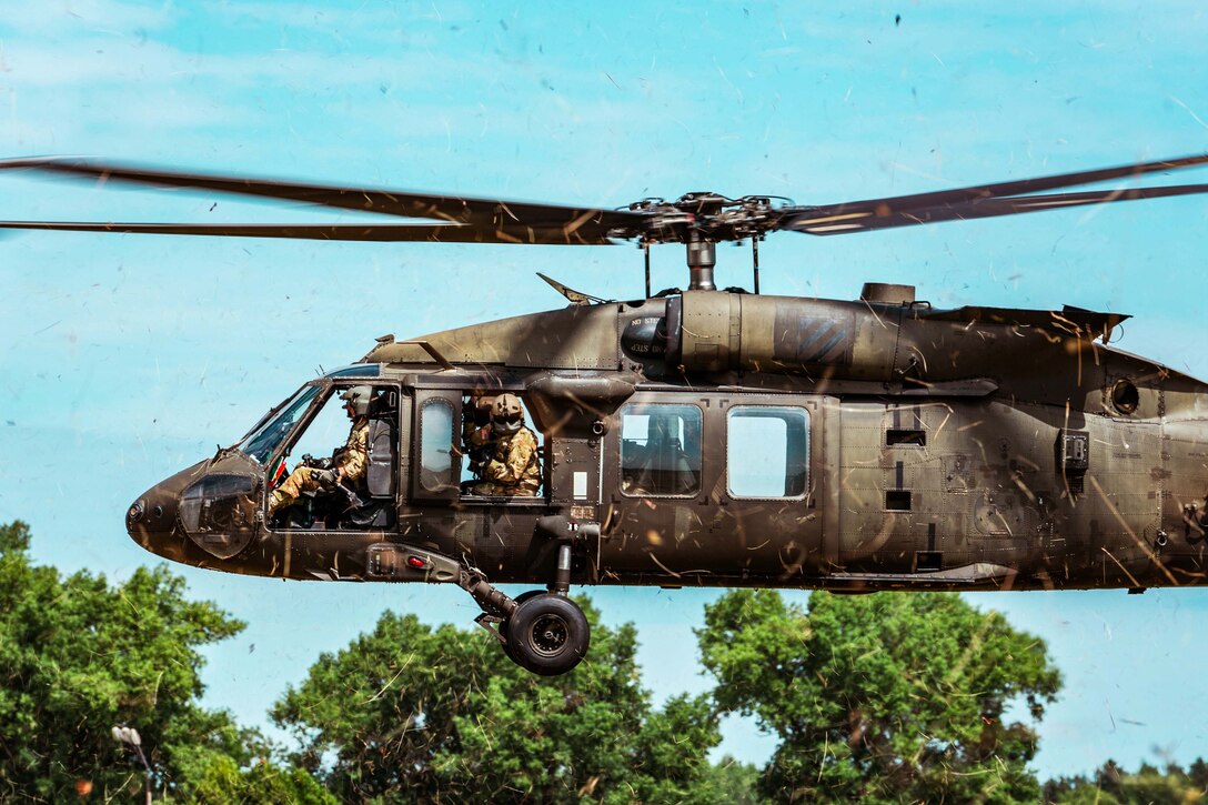 A soldier flies a helicopter.