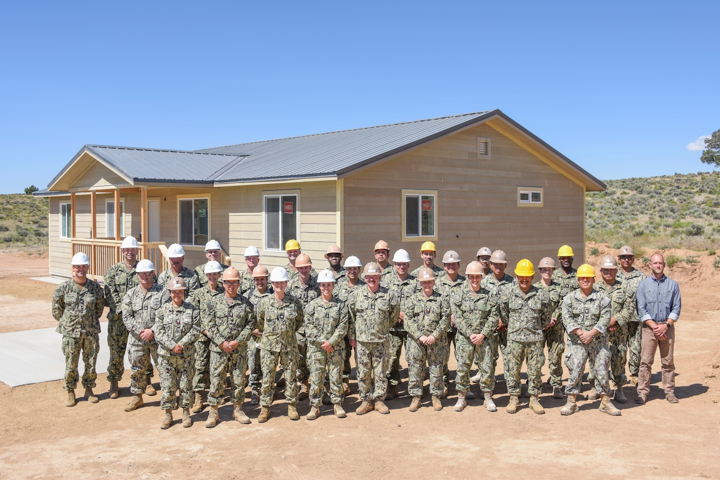 GALLUP, N.M. (June 15, 2023) Navy Reserve Sailors pose for a group photo in front of a newly constructed home they built as a charitable contribution and training opportunity in partnership with the Southwest Indian Foundation. The home's construction served to educate Seabees in various practical construction techniques needed for mission readiness while fulfilling the needs of a community partner as part of the Department of Defense's Innovative Readiness Training (IRT) program. Representatives from Naval Mobile Construction Battalion (NMCB) 18, FIRST Naval Construction Regiment (FIRST NCR) and Southwest Indian Foundation are depicted.