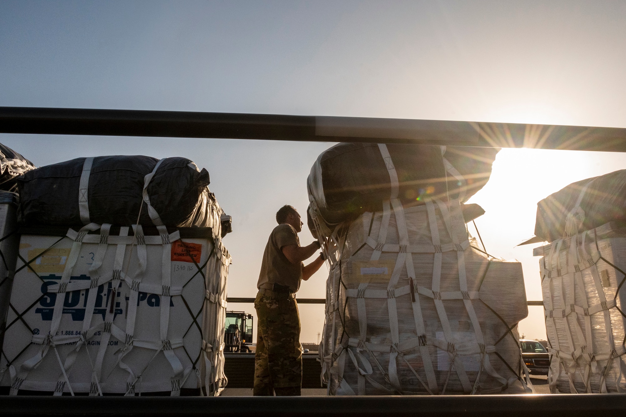 U.S. Air Force Tech. Sgt. Terrance Greenwood, 40th Expeditionary Airlift Squadron C-130 loadmaster, conducts final checks to ensure security of container delivery system bundles before loading onto an aircraft at Ali Al Salem Air Base, Kuwait, July 5, 2023.