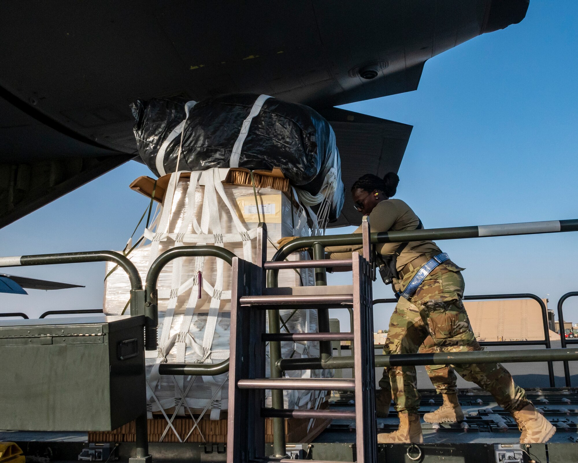 U.S. Air Force Senior Airman Keandra Mills, 386th Expeditionary Logistics Readiness Squadron ramp services specialist, pushes a container delivery system (CDS) bundle weighing 1,400 pounds onto a C-130 at Ali Al Salem Air Base, Kuwait, July 5, 2023.