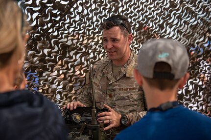 U.S. Air Force Maj. Jeffrey Hansen, 137th Combat Training Flight director of operations, Oklahoma National Guard, shows historic equipment used for close air support during the Tinker Air Show at Tinker Air Force Base, Oklahoma City, July 1, 2023. The 137th Special Operations Wing joined members of the total force at the Tinker Air Show, which showcased the diverse aspects of aviation. (U.S. Air National Guard photo by Tech. Sgt. Brigette Waltermire)