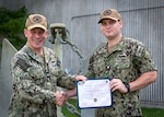 SILVERDALE, Wash. (Jun. 29, 2023) – U.S. Navy Capt. Michael D. Eberlein, left, commanding officer of Trident Refit Facility, Bangor (TRFB), presents a certificate to Hull Maintenance Technician 1st Class Austin Fortner. Fortner received recognition for completing his Navy Enlisted Classification (NEC) as a pipefitter under the Navy Afloat Maintenance Training Strategy (NAMTS) at TRFB. Fortner, currently attached to Naval Reserve Center-Houston, was mobilized under Surgemain from August 2020 to September 2021 where he enrolled under the NAMTS program to earn his pipefitter qualification. TRFB supports the nation’s strategic deterrence mission by repairing, incrementally overhauling, and modernizing Pacific Fleet strategic ballistic missile submarines during refits. (U.S. Navy photo by Mass Communication Specialist 2nd Class Sarah Christoph)